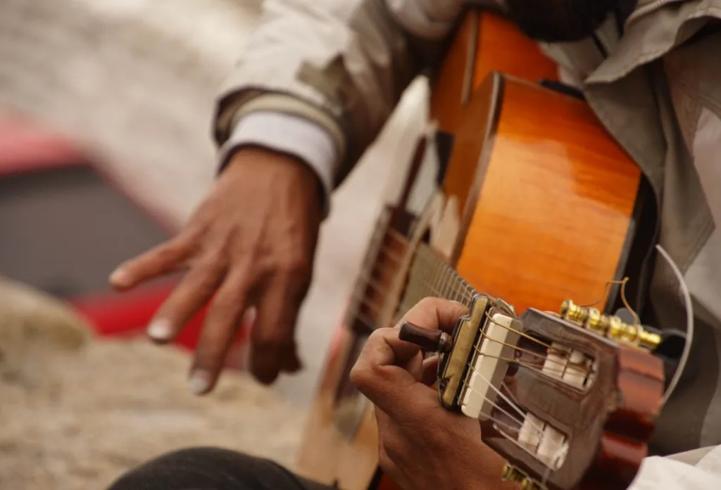 A guitar player strumming on an acoustic guitar.