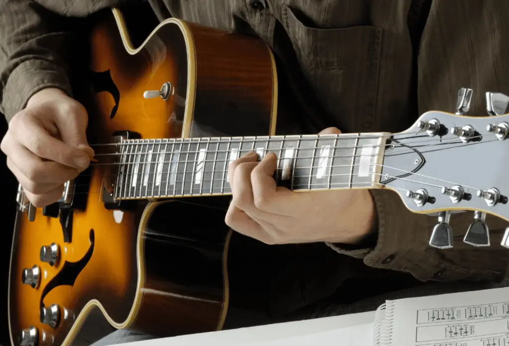 A man playing a jazz archtop guitar