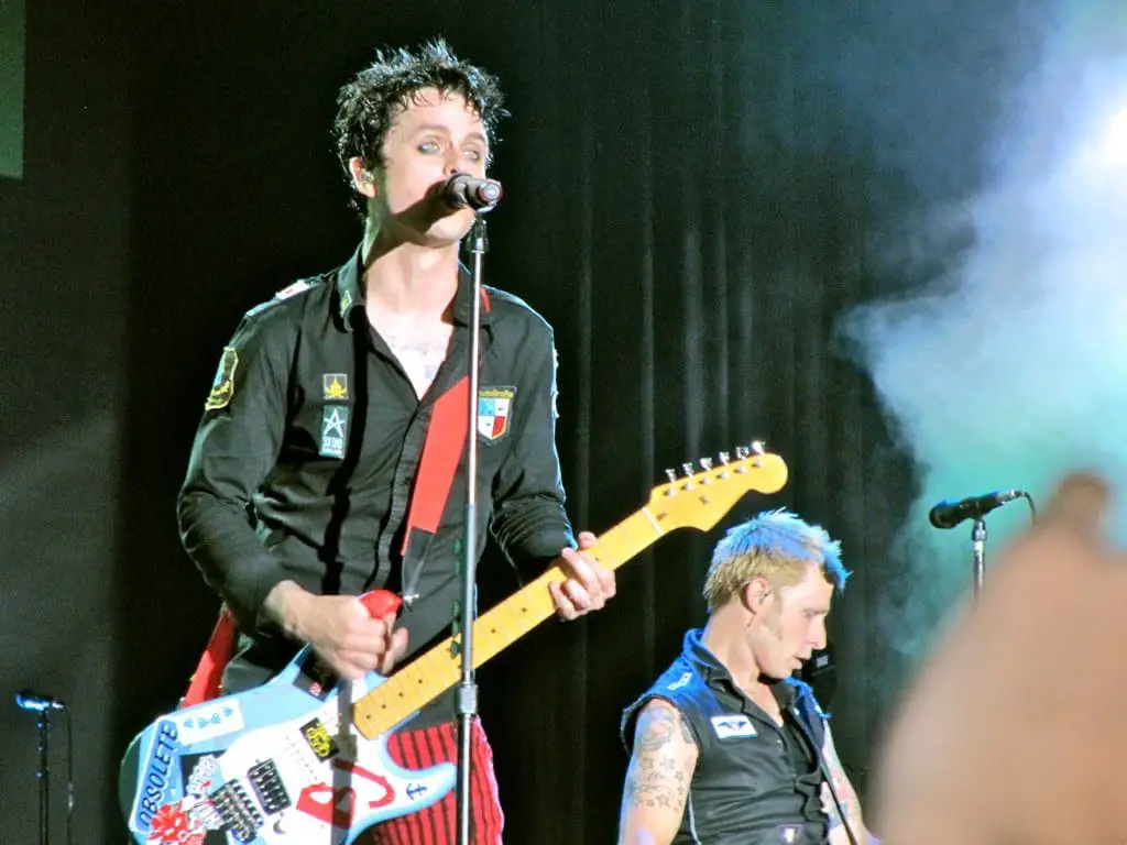 Green Day's Billy Joe playing guitar and singing in concert